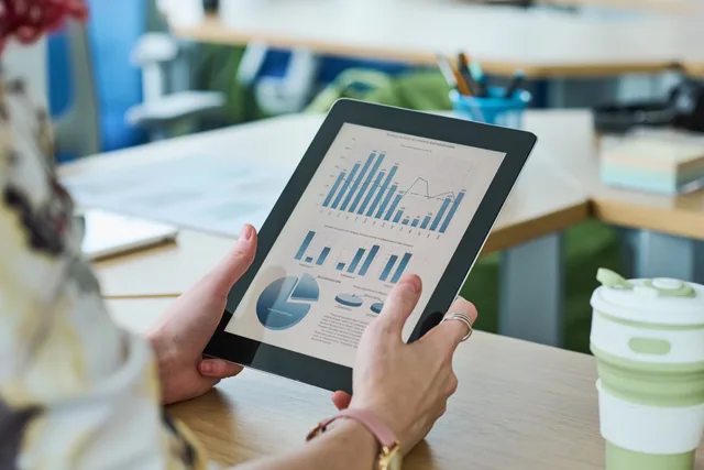 Hands reviewing campaign performance on a tablet
