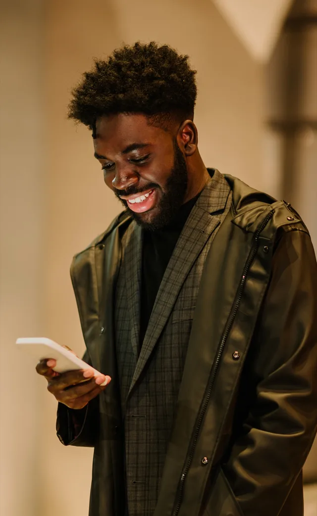 Person smiling while reading a message on a phone