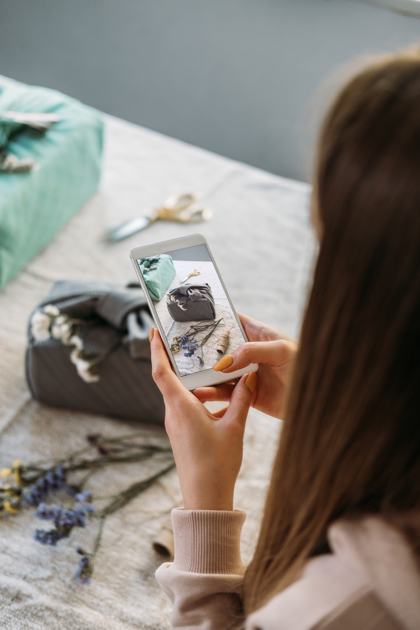 Person taking a photo of a wrapped gift on a phone