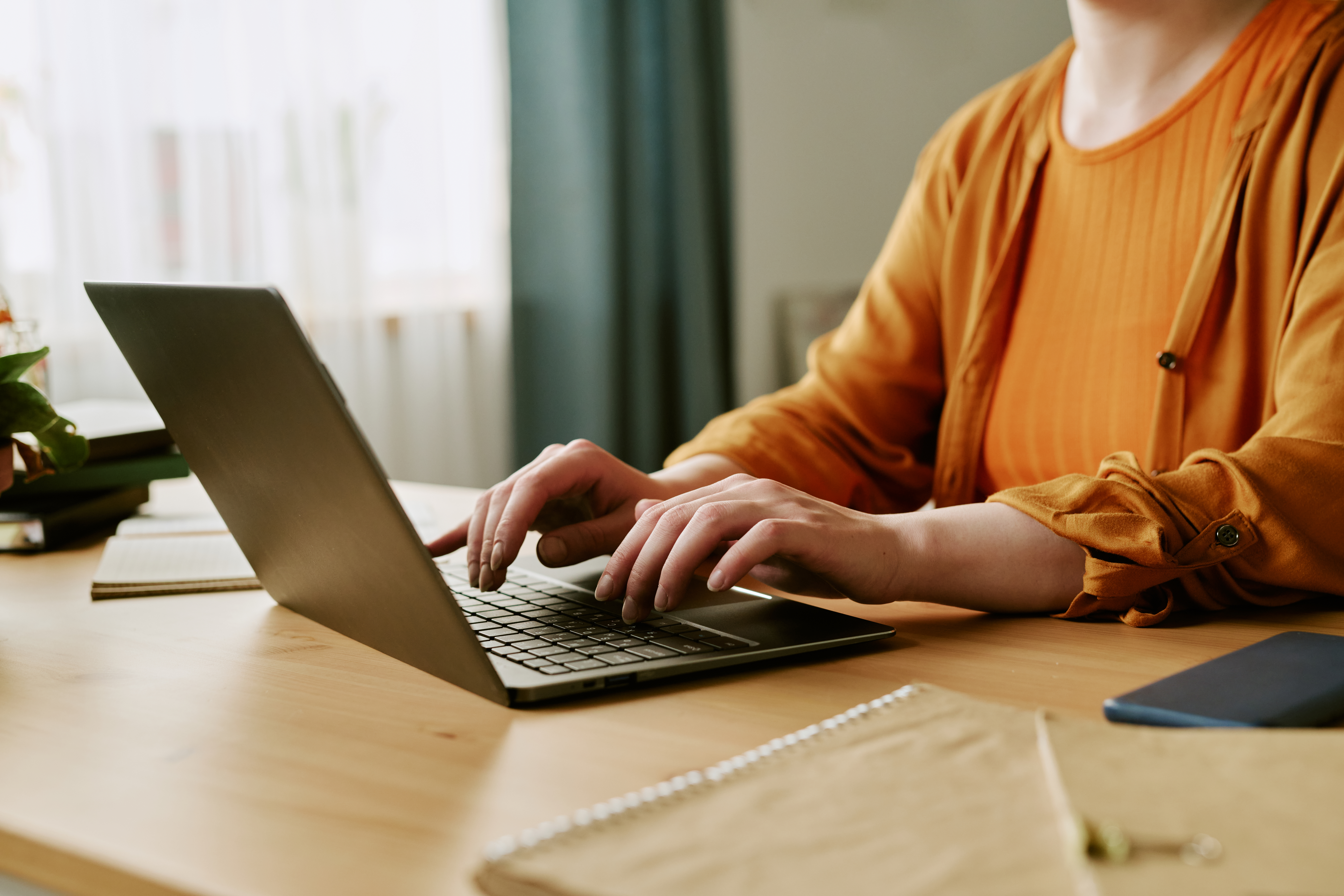 Young adult woman typing on a laptop