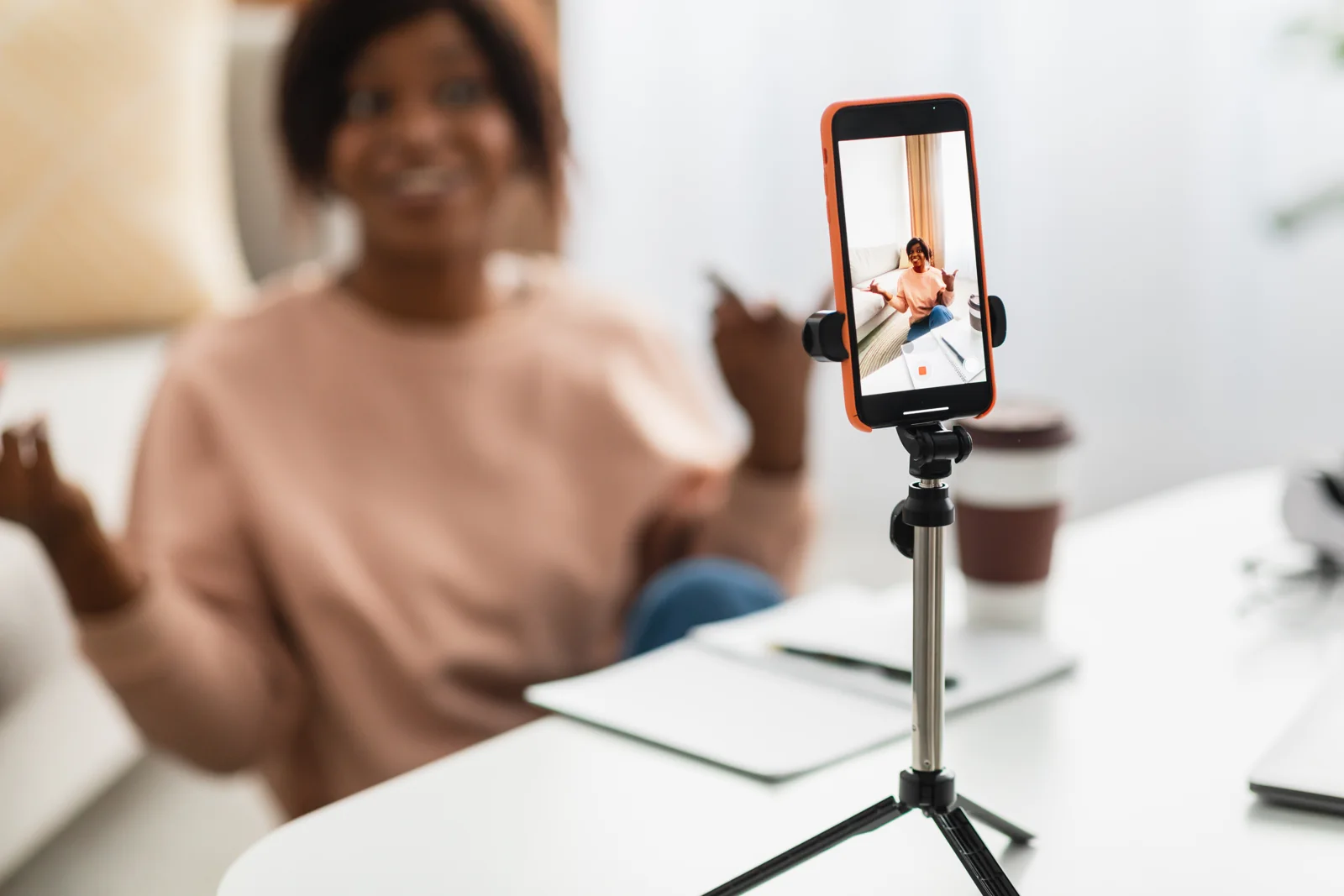 A creator films a video using a phone on a tripod