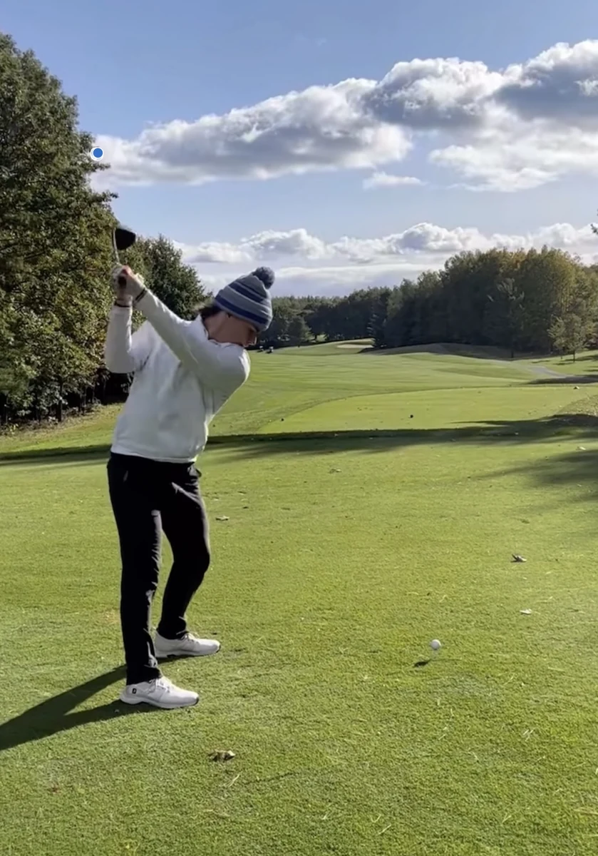 A golfer taking a swing on a golf course