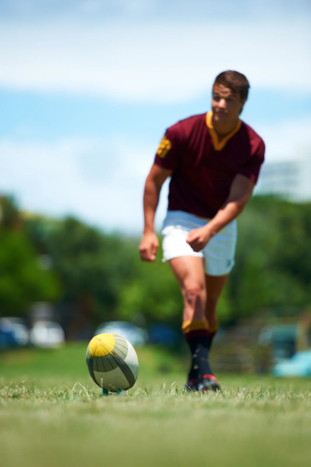 A soccer player prepares to kick a ball outdoors