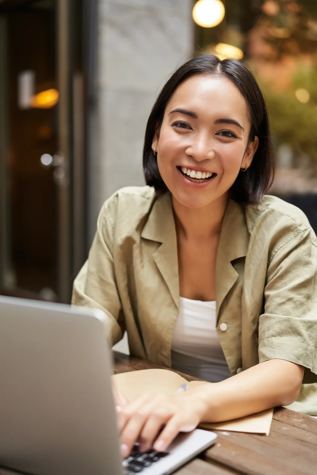 A creator smiles while working from a café