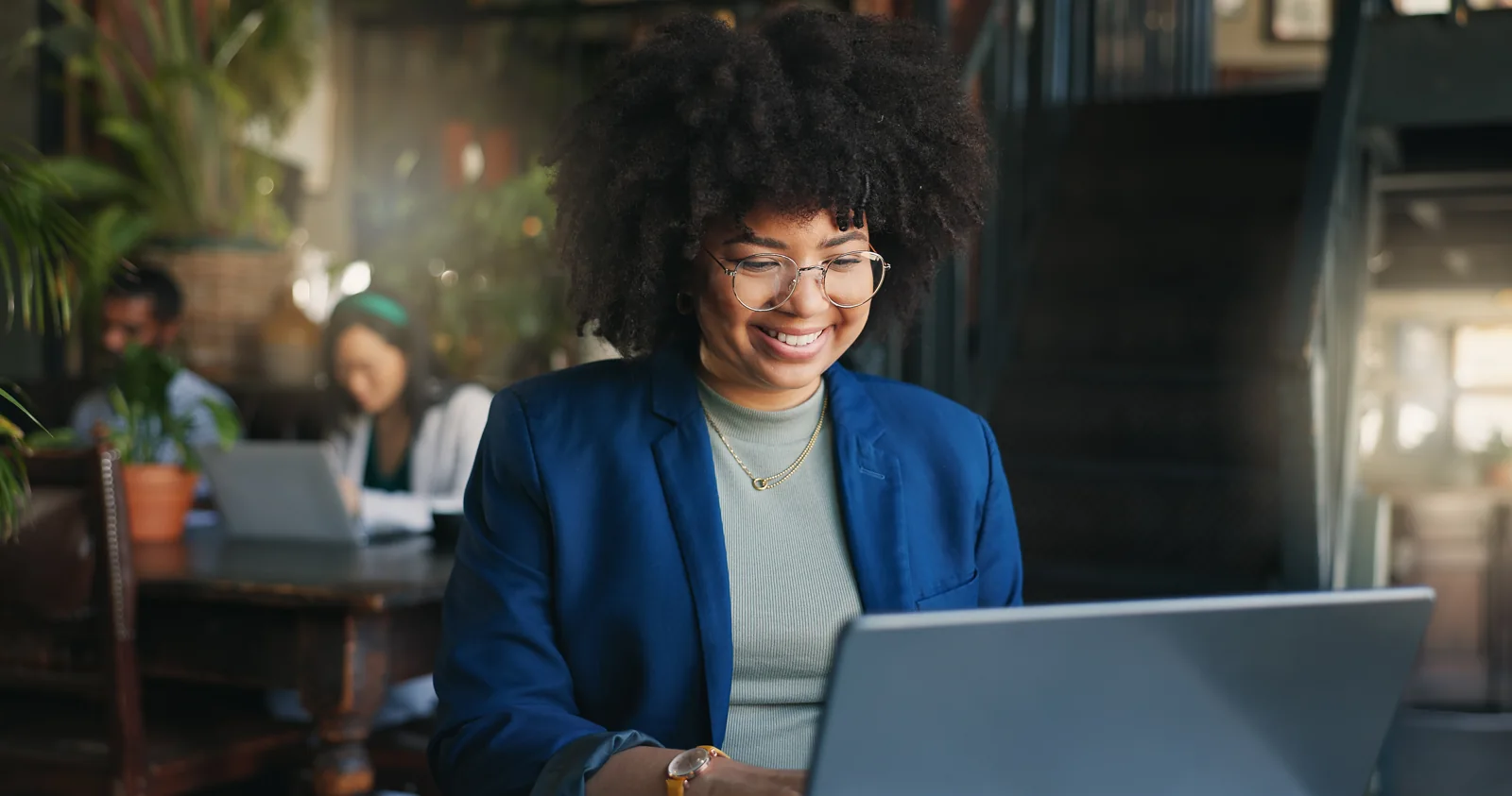 Smiling woman reviewing her work on a laptop